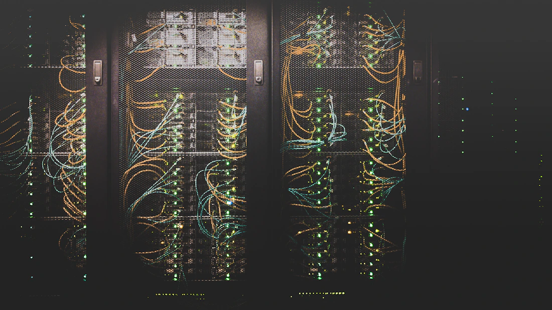 Corredor de um data center com fileiras de servidores iluminados